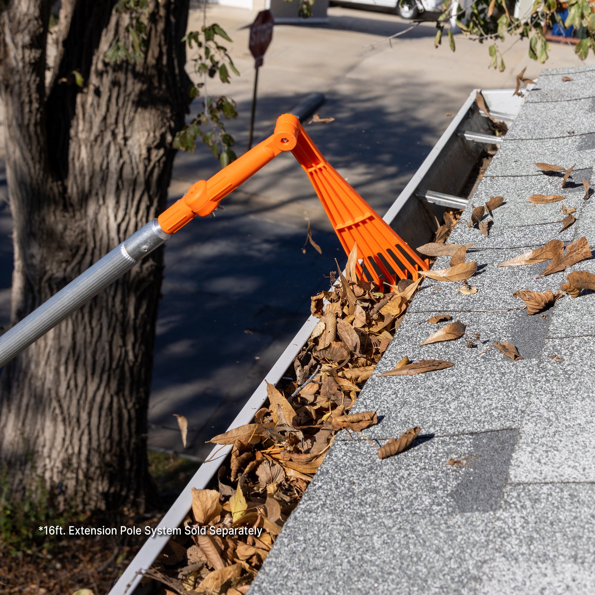 Mini rake connected to pole clearing gutter leaves; EZ Smart extension pole kit sold separately.