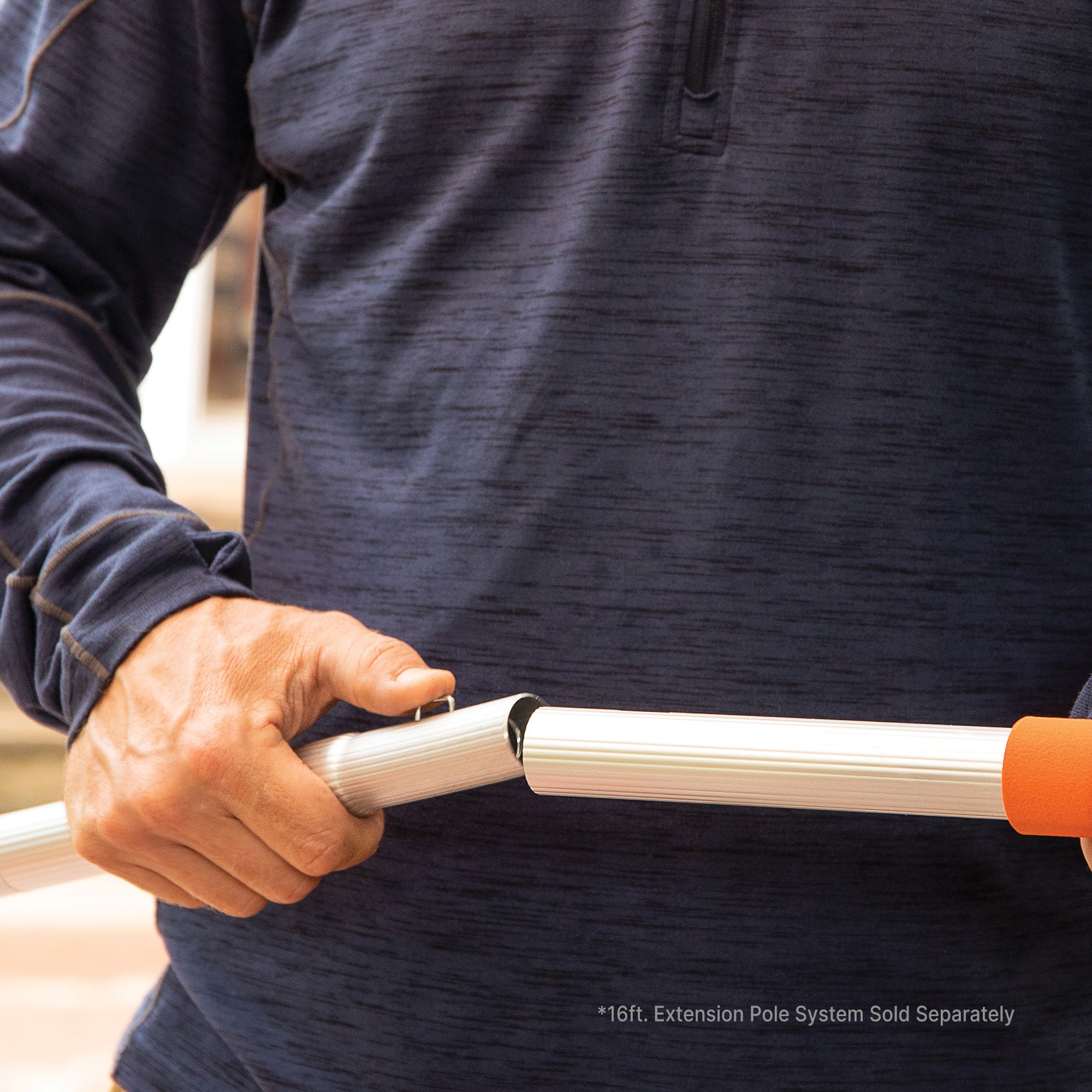 Man connecting Add-a-pole section with quick-connect clips; extension pole kit sold separately.