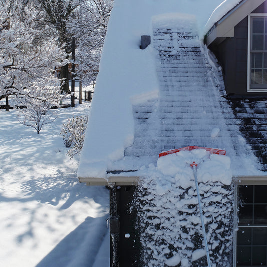 Snow roof rake removing snow to prevent ice dams